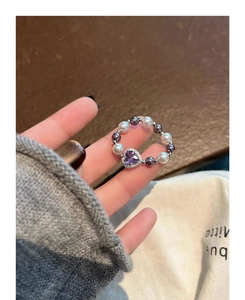 Detail of elegant stretch ring with purple heart gemstone and alternating pearl band