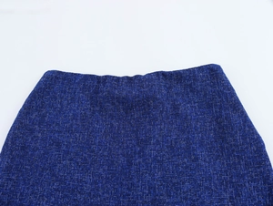 Close-up of blue tweed sleeveless suit set showing fabric texture and waist detail
