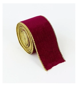 Macro shot of burgundy velvet Christmas ribbon with elegant gold metallic stitched edges