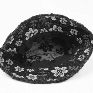 Internal view of denim bucket hat showing white flower embroidery and frayed edge details