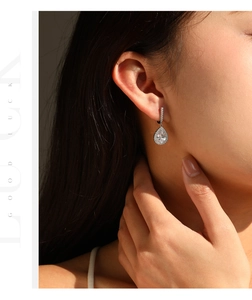 Macro detail of pear-cut crystal drop earrings with shimmering micro-pave silver setting