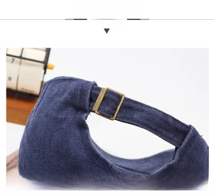 Detail of adjustable strap with bronze metal buckle on navy blue washed cotton cap