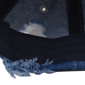 Detailed close-up of distressed denim baseball cap with inner sweatband and frayed edge