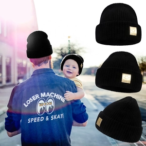 Three-piece family set of black knit beanies with a golden happy face smile patch