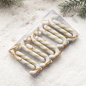 Pack of 6 white and gold candy cane ornaments with glitter stripes on festive pine background