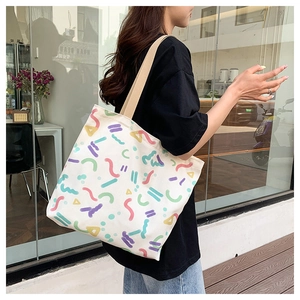 Detail of canvas tote bag with abstract geometric print worn over the shoulder