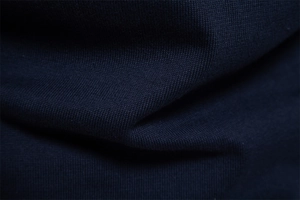 Macro close-up showing the fine knit texture and soft navy blue fabric of this men sweater