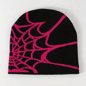 Detailed knit texture of a black streetwear beanie featuring a hot pink spider web pattern