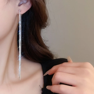 Close-up of long silver tassel earrings with rhinestones on model for elegant look