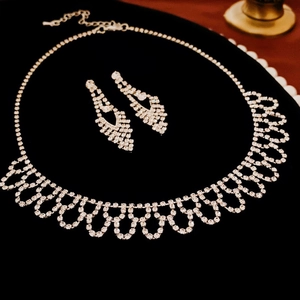 Dettaglio ravvicinato della collana con frange di strass e orecchini coordinati su velluto