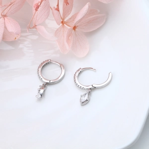 Macro detail of S925 sterling silver hoop earrings with marquise-cut zircon stones