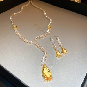 Vue macro du collier en Y doré et boucles d'oreilles aux cristaux jaunes en goutte