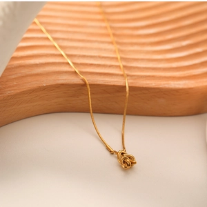Detailed view of an 18K gold-plated stainless steel sailor knot pendant necklace