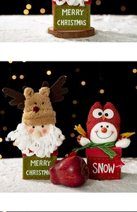 Detail of plush Santa and Snowman Christmas gift boxes with warm festive bokeh lighting