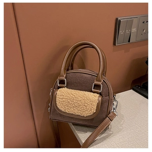 Detailed view of the mixed-texture handbag featuring brown suede and faux shearling flap