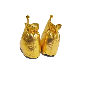 Detail of metallic gold clown shoes with curled toes and small bells for festive costumes