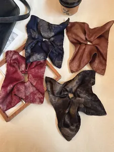 Close-up of four vintage square silk scrunchies with tie-dye textures in marble patterns