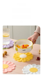 Close-up of floral silicone heat-resistant placemats in multiple sizes on a wooden table