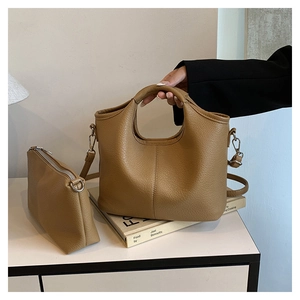 Close-up of camel brown lychee grain leather bucket bag set with silver hardware