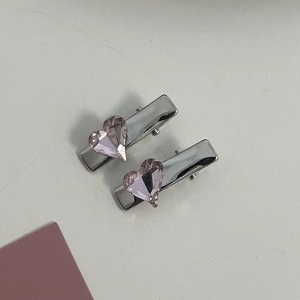 Macro view of silver alloy hair clips with sparkling pink heart-shaped rhinestones