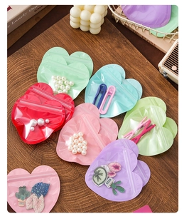 Macro detail of colorful heart-shaped self-sealing bags with pearls and small accessories