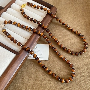 Detail of round tiger eye beaded necklaces with gold and silver metallic spacer beads