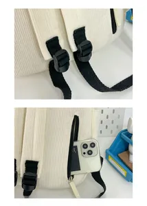 Detail of off-white corduroy backpack showing adjustable buckle and anti-theft back pocket