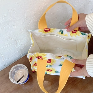 Detail of sunflower canvas lunch bag interior pocket and reinforced yellow handle
