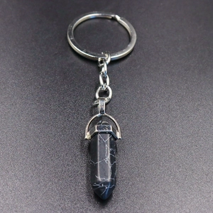 Macro detail of hexagonal natural stone pendant on a silver metal keychain