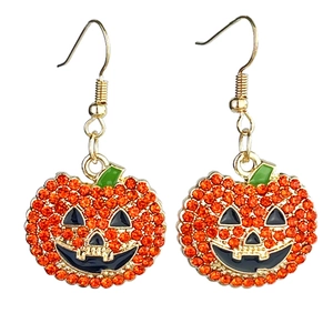 Macro detail of pumpkin earrings with orange rhinestones and black enamel accents