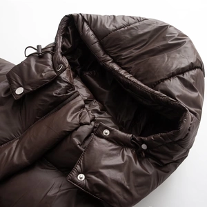 Detail der dunkelbraunen Steppjacke mit winddichter Kapuze und verstellbarem Kordelzug