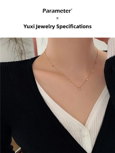 Detail showing gold titanium necklace with sparkling rhinestone triangular charms on model