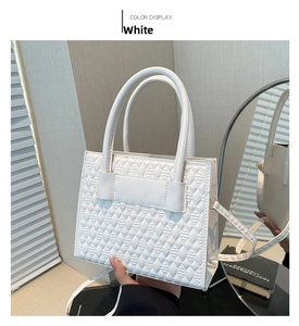 Detail der weißen gesteppten Handtasche mit schickem Rautenmuster und Doppelgriffen