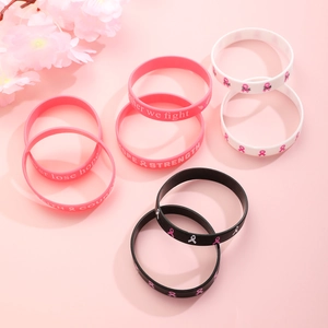 Detailed view of silicone breast cancer awareness wristbands with pink ribbons and slogans
