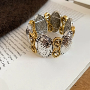 Detailed close-up of retro two-tone textured heart stretch bracelet on a vintage book