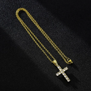 Detailed macro view of the gold cross pendant inlaid with sparkling white cubic zirconia