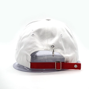 Detail of white baseball cap back with red adjustable strap and silver metal ring decor