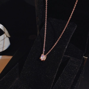 Detail view of round cubic zirconia solitaire pendant on rose gold titanium chain