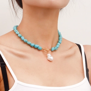 Macro shot of turquoise beads and a baroque pearl pendant on an OT toggle necklace