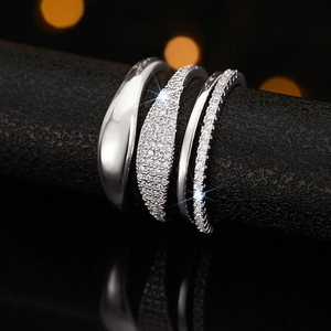Macro shot of a four-piece stackable silver ring set with zircon on a dark display