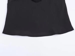 Close-up of black satin camisole hem featuring precise stitching and smooth fabric texture
