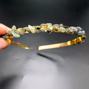 Detail of handmade gold headband featuring colorful natural crystal stones on wire