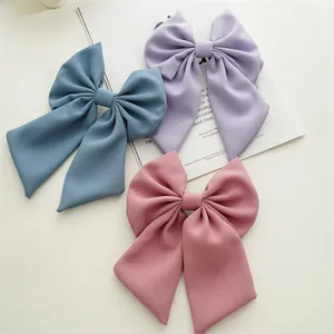 Detailed view of three chiffon bow hair clips in blue, purple and dusty pink morandi colors