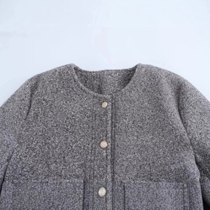Veste grise en maille bouclée avec col rond et boutons décoratifs en métal doré