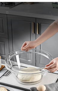 Close-up of a large transparent flour basin with lid showing dough rising process