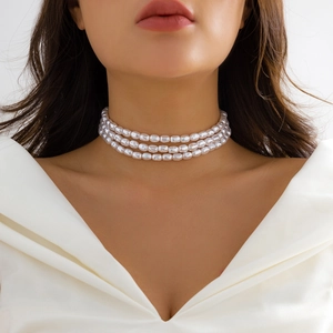 Detailed close-up of a three-row white pearl choker necklace with radiant luster