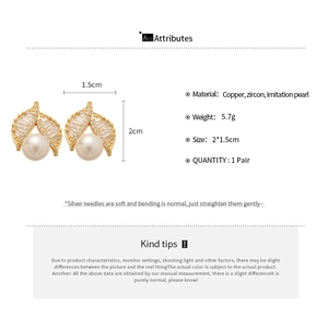 Detail view of gold-plated leaf earrings with cubic zirconia and faux pearl accents