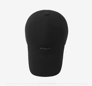 Close-up of black baseball cap with grey Paris embroidery and thick gridded fabric texture