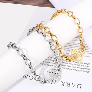 Gold and silver punk chain bracelets with Tree of Life pendants on a book