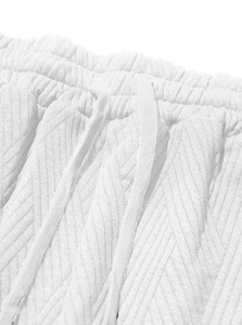 Detailed view of white athletic shorts featuring textured fabric and adjustable drawstring